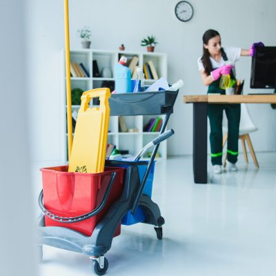 young-female-janitor-cleaning-office-with-various-cleaning-equipment-1.jpg